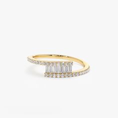 a yellow gold ring with baguets and diamonds on the sides, set against a white background