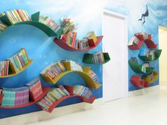 there are bookshelves in the shape of dolphins on the wall and below them is a book shelf