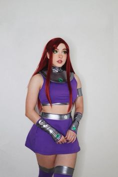 a woman with red hair in a purple outfit