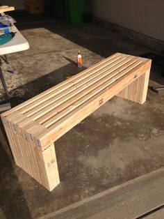 a wooden bench sitting on top of a cement floor