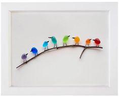 a group of birds sitting on top of a branch in front of a white wall