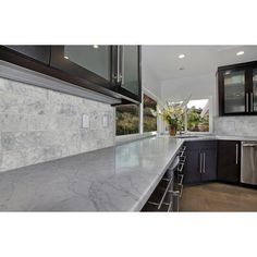 a kitchen with marble counter tops and stainless steel appliances