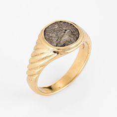 Stylish vintage Bulgari ancient coin ring crafted in 18 karat yellow gold (circa 1970s to 1980s).  The iconic coin ring was created by Bulgari back in the 1960s. The enduring ''Monete'' design is very popular to this day with Bulgari recently releasing new pieces to the collection. The ring is signed "Bactrie 171-135 AV.J.C." and is smaller in scale, suitable for wear on the pinky finger if desired.  The ring is in very good original condition and was recently lightly cleaned and polished.  Part Ancient Style Collectible Yellow Gold Rings, Ancient Gold Engraved Signet Ring, Ancient Style Yellow Gold Signet Ring Gift, Ancient Style Engraved Gold Signet Ring, Gold Engraved Signet Ring With Antique Style, Ancient Yellow Gold Intaglio Ring, Ancient Gold Collectible Rings, Ancient Intaglio Rings, Ancient Oval Gold Rings