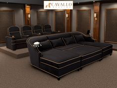 an empty theater with black couches and gold trimmings on the walls,