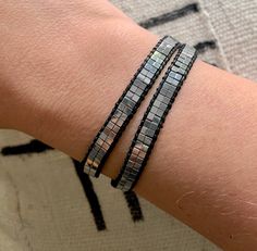 Add interest and style to any outfit with this eye-catching wrap bracelet. Features Silver Hematite Gemstone Beads with lots of sheen. Easily wraps around the wrist twice with a silver button closure. Several button holes for a customized fit on any wrist. No guesswork on sizing, making this a great gift! Total length is 17 inches. {Hematite is a natural gemstone with a metallic look and feel} Modern Adjustable Silver Wrap Bracelet, Silver Beaded Bracelets With Faceted Beads For Festivals, Modern Silver Bracelet With Black Beads, Modern Silver Beaded Bracelet With Black Beads, Handmade Silver Wrap Bracelet For Party, Handmade Adjustable Wrap Bracelet For Party, Adjustable Nickel-free Modern Beaded Bracelets, Bohemian Silver Wrap Bracelet With Faceted Beads, Silver Hematite Beaded Bracelets With Black Beads