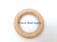 a wooden ring with the words princess bead supply written in black ink on it