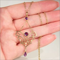 "My friend Judy has the best taste in lavaliere pendants and necklaces. Every time I go to London she has a little bundle of them set aside for me. She knows just what I like, not the plain, boring ones, no, no, I like the fancy ones, with a combination of gems, white, green, purple, blue, any combo will do! Here's one she had set aside for me last time, a lovely shape, with wonderful movement and bright gems, contrasting with creamy pearls. Hand crafted 9 karat gold Edwardian Lavaliere necklace 14k Gold Art Nouveau Pendant Necklace, Art Nouveau 14k Gold Pendant Necklace, Art Nouveau 14k Yellow Gold Necklace, Purple Art Deco Necklace For Gift, Fantasy Jewelry, Spring Green, Jewelry Tutorials, Purple Amethyst, White Green