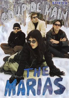 two men and a woman sitting on the ground in front of an advertisement for their band