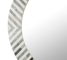 a round mirror with an abstract design in the middle and stripes on the outside of it