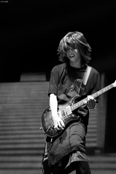 a young man playing an electric guitar on stage