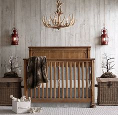 a baby crib in the middle of a room with deer antlers on the wall