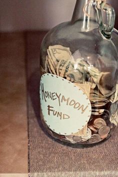 a glass jar filled with money sitting on top of a table