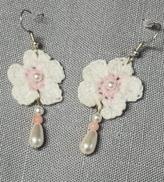 Handmade pearl beaded crochet earrings with sterling silver wires, dangling flowers, pearls, and beads. These cute earrings are perfect for a birthday present, Mother's Day surprise, or bridesmaid gift.  Dress up any outfit, from your favorite sundress to your most comfy jeans, with these distinctly romantic floral crochet earrings. Soft pretty hues blend with pearl accents to create the perfect accessory for your wardrobe. Lightweight and colorful with a feminine flair, you will love wearing our jewelry.  Sterling silver wires come with plastic backs for secure wear. Gold wires are sterling silver with gold plating. Flowers are crafted of cotton thread, embellished with metal and plastic beads. Flower is approximately 3x3 cm. Hanging length approximately 6 cm. Handmade Flower Pearl Earrings, Handmade Flower-shaped Pearl Earrings, Handmade Pearl Dangle Flower Earrings, Spring White Pearl Earrings, Handmade Pearl White Flower Earrings, Handmade White Flower Beaded Earrings, Handmade White Flower Pearl Earrings, Pink Crochet Dangle Jewelry, Handmade Delicate White Pearl Earrings