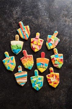 decorated cookies are arranged on a black surface