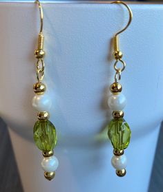 These dangling Light green acrylic beads with pearl and gold tone beads create a fresh look for spring or St. Patrick's Day. Wear them with jeans or dress up and wear them on a special occasion. These earrings or two or three pairs of earrings would make a perfect gift to friends and family and even yourself. Give as a gift for a variety of holidays such as Christmas and Easter or a life event including birthdays, anniversaries, and graduations.  If you have something different in mind please contact me and I can make you a custom order just for you! Jewelry Care As will all jewelry remove before showering, sleeping and activates that cause sweating.Everything is made to order and assembled by hand with love, care, and attention to detail.  This item or two or three items would make a perf Spring Gold Jewelry With Pearl Drop, Spring Pearl Drop Gold Jewelry, Spring Pearl Drop Gold Earrings, Gold Pearl Drop Earrings For Spring, Spring Gold Pearl Drop Earrings, Green Dangle Earrings For Spring, Green Dangle Pearl Earrings, Green Pearl Dangle Earrings, Spring Green Dangle Earrings