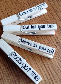 four wooden clothes pins with words on them that say god is bigger than you believe in yourself