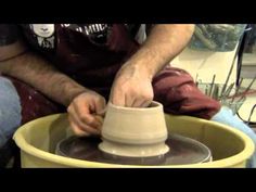 a man is making a vase out of clay