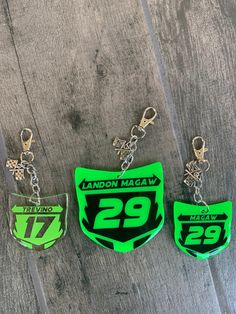 three keychains with the number twenty two and twenty four on them, hanging from chains