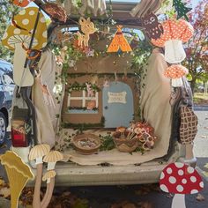 the back of a van decorated with paper mushrooms and other things in front of it