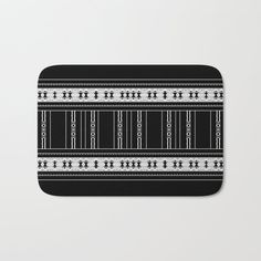 a black and white bath mat with an abstract design on it, featuring lines in the middle