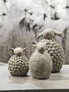 three ceramic sheep sitting next to each other on a table