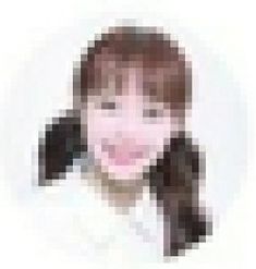 a pixellated photo of a woman's face with brown hair and pink cheeks