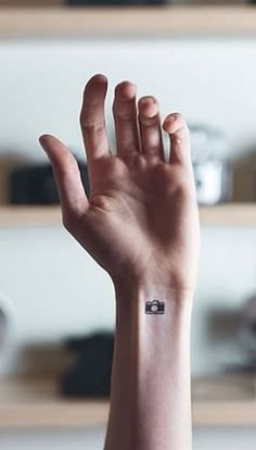 a woman's arm with a small tattoo on the middle of her left wrist