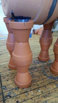 two large brown vases sitting on top of each other in front of a wall