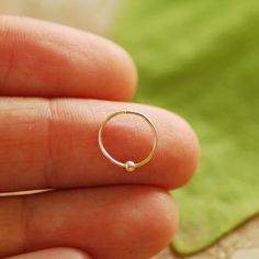 ♥ The perfect gift for you or your loved ones ♥ SINGLE hoop earring with a tiny 14k gold / silver sterling ball Please note - tiny bead is not glued to the hoop, it moves along the hoop. ★PLEASE choose★: - hoop with secure locking clasp - hoop with tiny claps -please see photo #3 or - infinity endless hoop - hoop without clasp - please see photo #4 Please choose material: ★100% 14K gold filled ★ ★100% Silver Sterling ★ *you can choose also mix option - silver hoop with gold filed ball or gold fi Internally Threaded Round Nose Rings As Gift, Round Internally Threaded Nose Rings For Gifts, Hypoallergenic Huggie Cartilage Earrings As Gift, Tiny Nose Rings Perfect For Gifts, Adjustable Huggie Piercings As Gift, Delicate Hypoallergenic Cartilage Earrings Gift, Nickel-free Round Nose Rings As Gift, Minimalist Internally Threaded Nose Rings, Hypoallergenic Small Hoop Piercings For Gifts