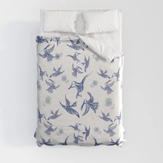 a bed with blue and white birds on it