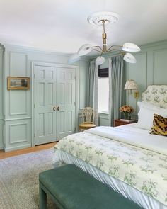 a bed sitting in a bedroom next to a green door and window covered with curtains