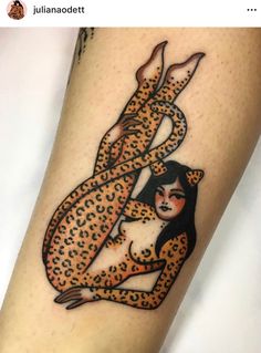 a woman with a leopard print on her leg is holding onto a cheetah