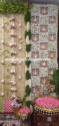 the wall is decorated with flowers and hanging decorations on it's sides, along with other decorative items