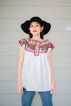 "This vintage Mexican hand embroidered cross stitch blouse is made from lightweight cotton with beautiful crochet birds and floral cross stitch in colour mix. Condition: In Very Good Vintage Condition **small brown spot under the bust (front) 3 small spots (back) shown in the last picture Details and Measurements (Inch) size estimate: L *Measurements are taken in inches with the garment laying flat. BUST: 40 \" FULL LENGTH: 27.5 \" SLEEVES LENGTH: 3.5\" Material = cotton, cross stitch,crochet Ou Spring Peasant Top With Multicolor Embroidered Neckline, Summer Cotton Peasant Top With Intricate Embroidery, Spring Peasant Top With Multicolor Intricate Embroidery, Summer Peasant Top With Embroidered Neckline, White Bohemian Peasant Top With Embroidered Hem, Bohemian Peasant Top With Multicolor Embroidered Neckline, Spring Peasant Top With Multicolor Geometric Embroidery, Multicolor Embroidered Cotton Peasant Top, Summer Peasant Top With Geometric Embroidery