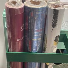 several rolls of wrapping paper are stacked on a shelf next to each other in a storage unit