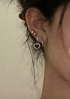 a close up of a person's ear with two earrings on top of it