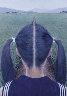 the back of a woman's head with long black hair in front of a green field