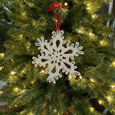 a snowflake ornament hanging from a christmas tree