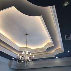 a chandelier hanging from the ceiling in a room with blue walls and ceilings