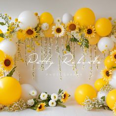 yellow and white balloons, sunflowers and greenery decorate the backdrop for this photo