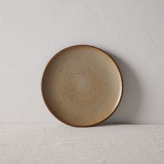 a brown plate sitting on top of a white table