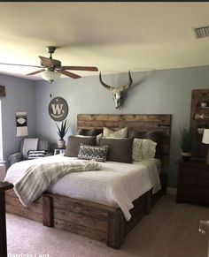 a bed room with a neatly made bed and a ceiling fan on the wall above it