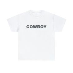 "Introducing our \"Cowboy\" t-shirt, a rugged and stylish addition to your wardrobe that captures the spirit of the Wild West. This t-shirt celebrates the timeless appeal of cowboy culture with its bold \"Cowboy\" print. Whether you're a true country enthusiast or simply admire the adventurous cowboy lifestyle, this tee is designed to make a statement. Made from comfortable and durable fabric, it's perfect for both casual outings and rodeo-ready looks. Embrace your inner cowboy or cowgirl and show off your love for all things Western with this classic \"Cowboy\" t-shirt. Saddle up and make it your go-to choice for a touch of frontier flair in your everyday style! The unisex heavy cotton tee is the basic staple of any wardrobe. It is the foundation upon which casual fashion grows. All it ne White Western T-shirt For Rodeo, White Letter Print Top For Rodeo, White Crew Neck Tops For Western-themed Events, White Graphic Tee For Western-themed Events, Western Style Cotton T-shirt For Rodeo, White Graphic Print T-shirt For Western-themed Events, White Crew Neck T-shirt For Rodeo, White Short Sleeve T-shirt For Rodeo, Trendy Crew Neck T-shirt For Ranch