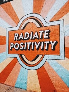 the word radiate positivity painted on a wall with sunbursts