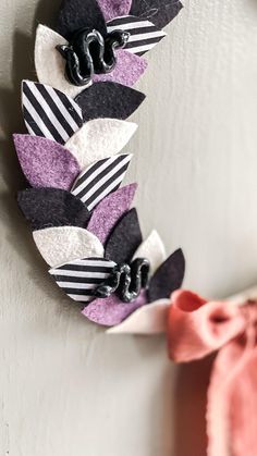 a close up of a wreath on a wall near a bow tie and other decorations