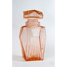 an orange glass bottle sitting on top of a white table