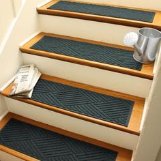 a set of stairs with a newspaper and cup on the floor next to each step