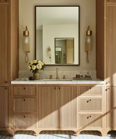 a bathroom with wooden cabinets and a large mirror