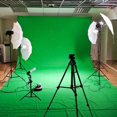 the green screen is set up in front of two camera's and three light stands