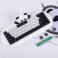 a keyboard with a panda bear key board on top of it and other items around it